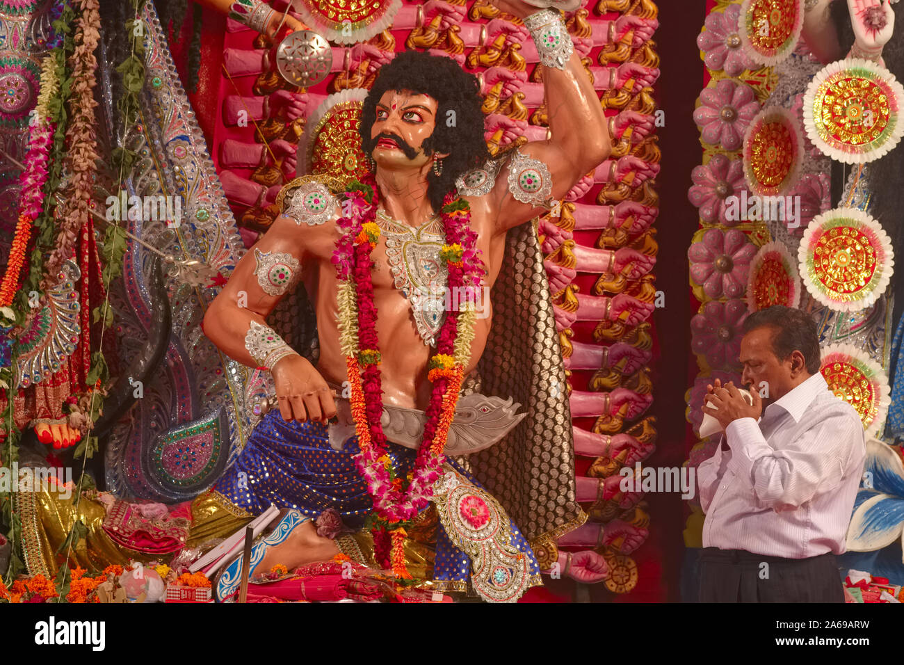 Während die hinduistische Fest Durga Puja in Mumbai, Indien, auf einer Stufe mit einem Hindu Statue, ein Hindu bläst auf ein Conch Shell (shankh), ein religiöses Ritual Stockfoto