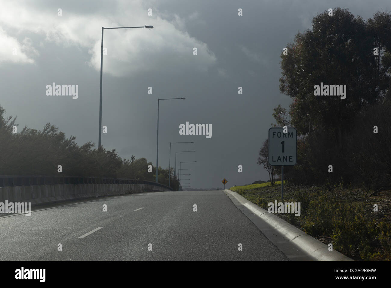 Ominösen cloudscape overhead National Highway auf der Rampe zusammenführen Lane. Stockfoto