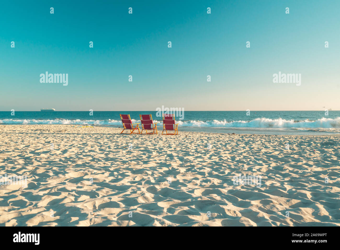 Sonnenuntergang am Strand. Schöne leere Sand Strand und 3 Liegestühle am Strand Stockfoto