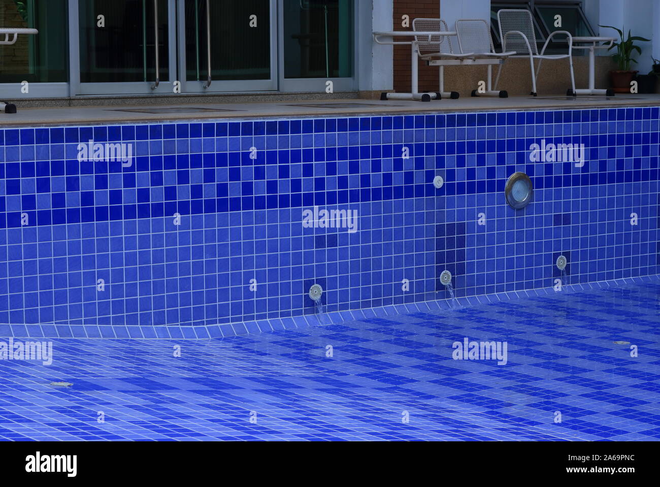 Closeup schnell fließendem Wasser aus der Steckdose in den leeren Pool nach der Renovierung und Reinigung, in der der volle Ölfluß Konzept, Metapher Stockfoto