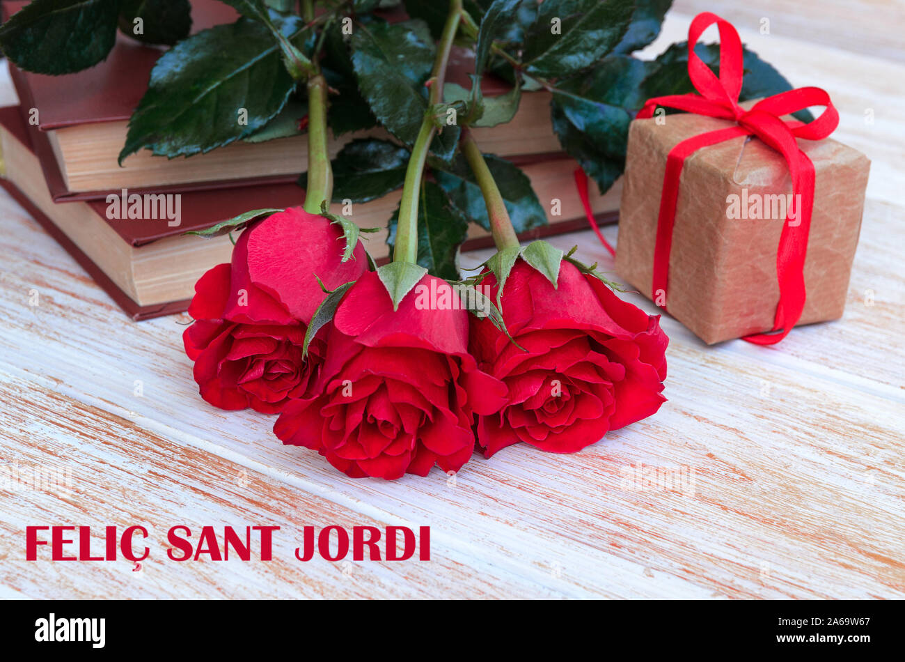 Alte Bücher und red rose, traditionelle Geschenk für Sant Jordi, das Saint Georges Tag. Catalunya's Version von Valentinstag. Phrase Happy Saint Georges in c Stockfoto