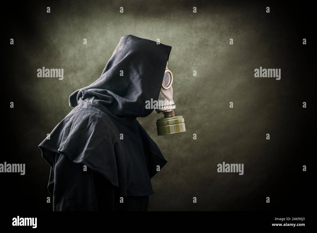 Mann in einem Gas Maske und Umhang mit Kapuze. Umwelt Umweltverschmutzung. Stockfoto