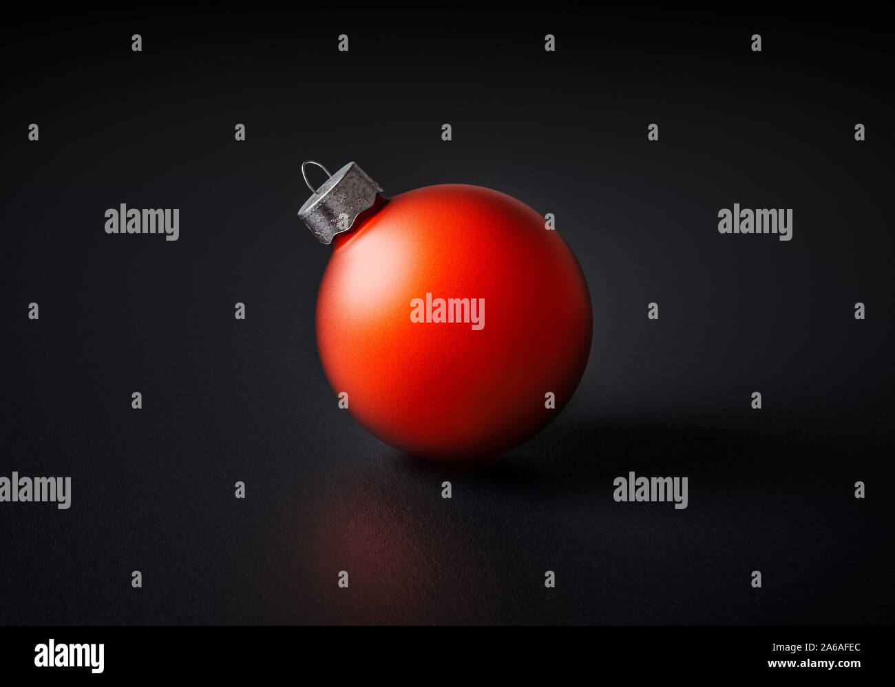 Matt Rot Weihnachtskugel zentriert auf einem dunkelgrauen Hintergrund für saisonale Urlaub feiern und Themen Stockfoto