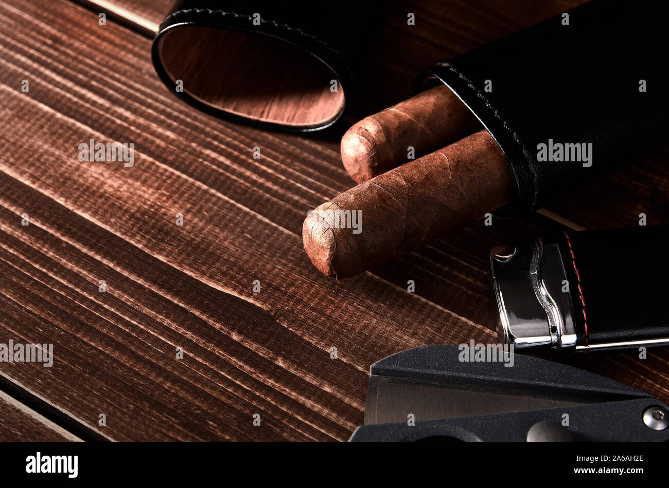 Stillleben mit kubanischen Zigarre in Ledertasche, Cutter und leichter auf alten Holzplatte Tisch mit Platz für Text. Stockfoto