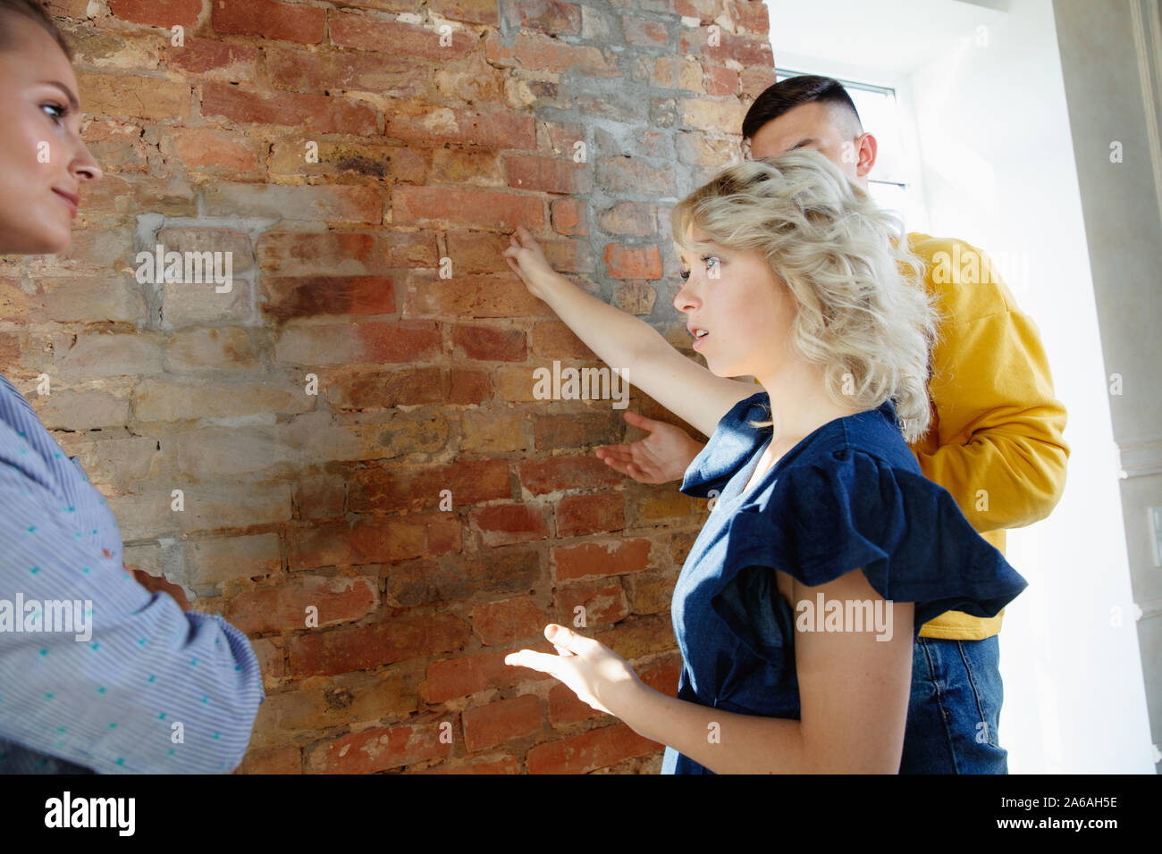 Interior Designer arbeiten mit jungen Paar. Sehr nette Familie und professionellen Designer oder conept architector Erörterung künftiger Innenraum, Arbeiten mit Farbpalette, Zimmer Zeichnungen in modernen Büro. Stockfoto