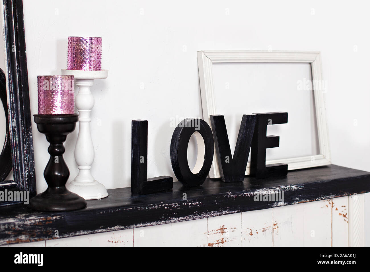 Das Wort Liebe ist. Auf den Kamin sind zwei Kerzenständer mit Kerzen und den hölzernen Wort Liebe. Liebe Inschrift in Holz- briefe. Stockfoto Das Wort Liebe ist. Auf den Kamin sind zwei Kerzenständer mit Kerzen und den hölzernen Wort Liebe. Liebe Inschrift in Holz- briefe. Stockfoto
