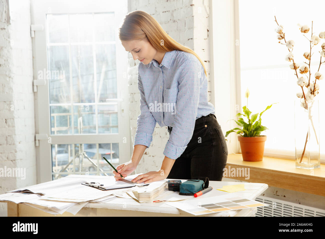 Professionellen Innenarchitekten oder architector Arbeiten mit Farbpalette, Zimmer Zeichnungen in modernen Büro. Junge weibliche Modell der Planung zukünftiger eine Wohnung oder ein Haus, die Auswahl der Farben und derocation. Stockfoto