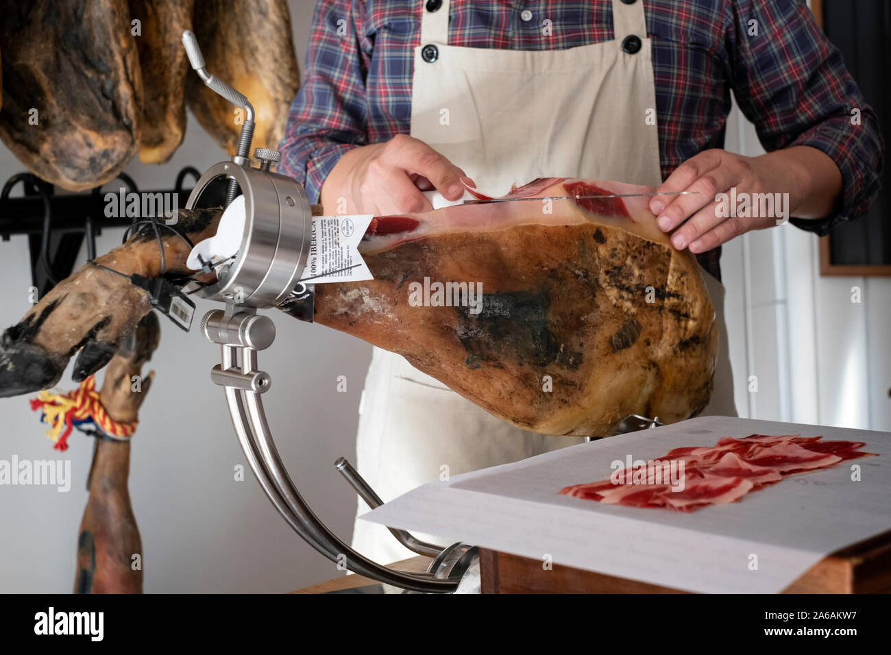 Mann mit einem Messer schneiden Schinken in einem ham Halter Stockfoto