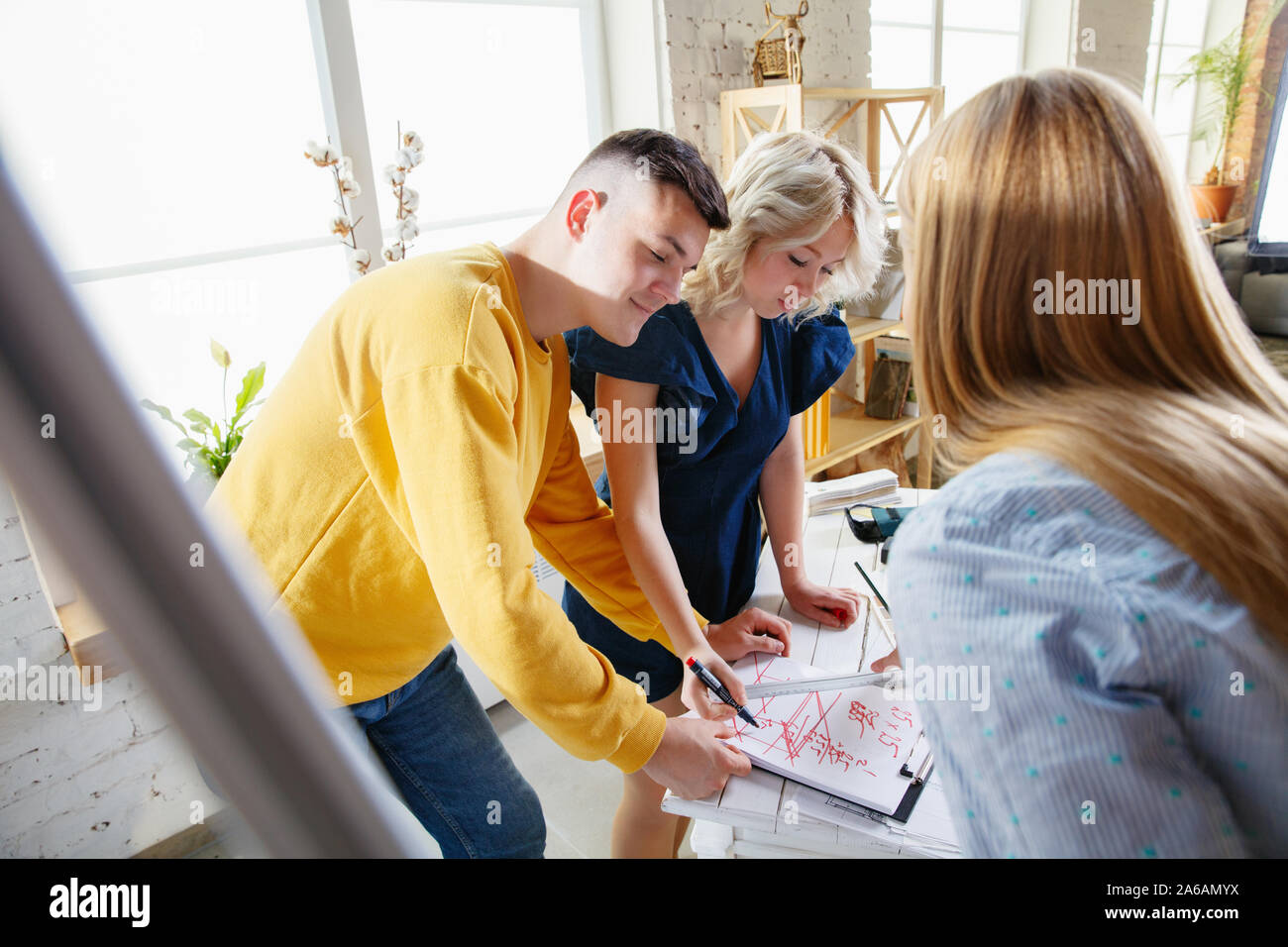 Interior Designer arbeiten mit jungen Paar. Sehr nette Familie und professionellen Designer oder conept architector Erörterung künftiger Innenraum, Arbeiten mit Farbpalette, Zimmer Zeichnungen in modernen Büro. Stockfoto