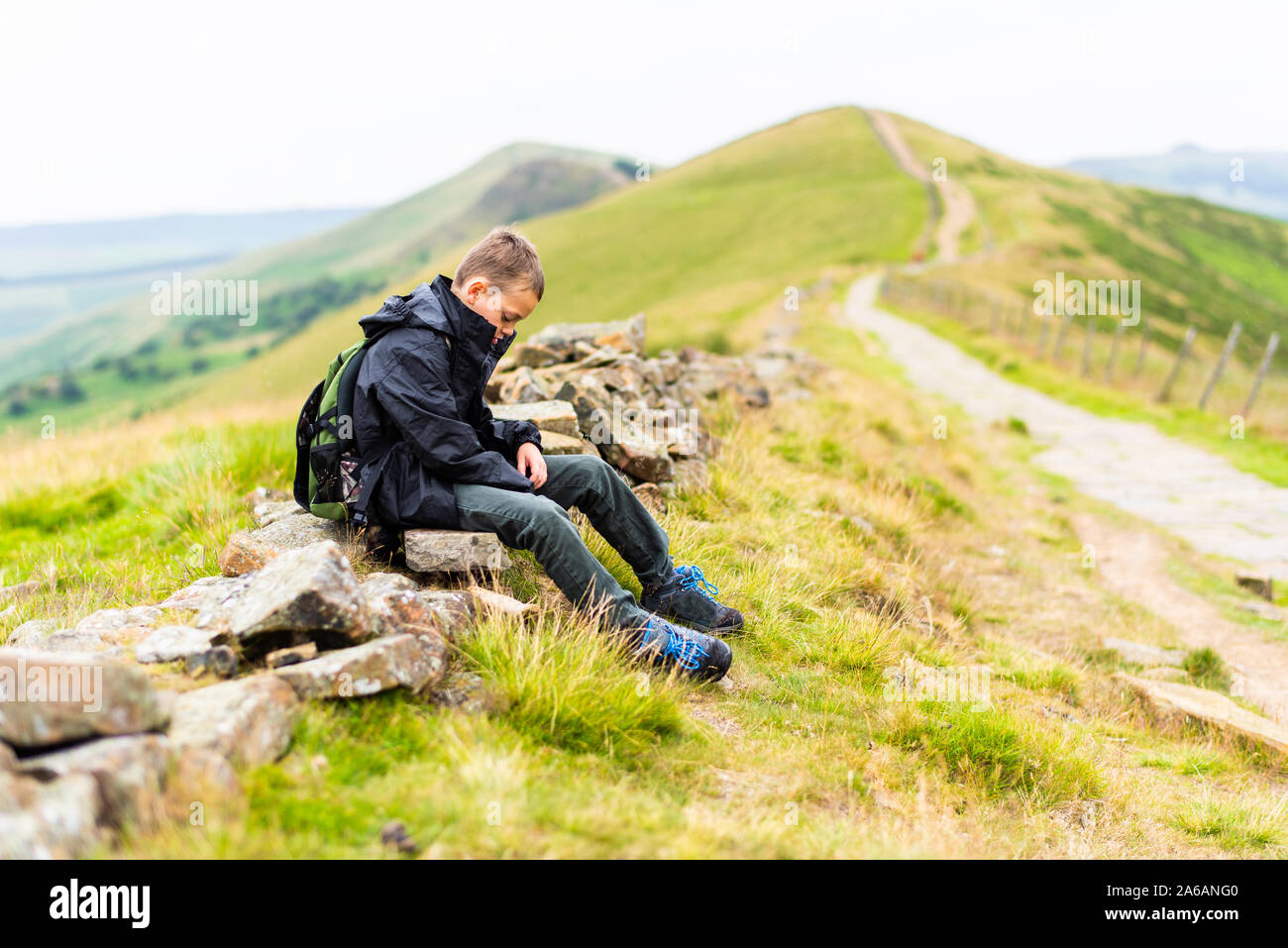 Einen kleinen Jungen mit ADHS, Autismus, Asperger-syndrom sitzen einsam und isoliert werden, während beim Wandern und Bergsteigen, die Große Ridge, psychischen Erkrankungen, Stockfoto