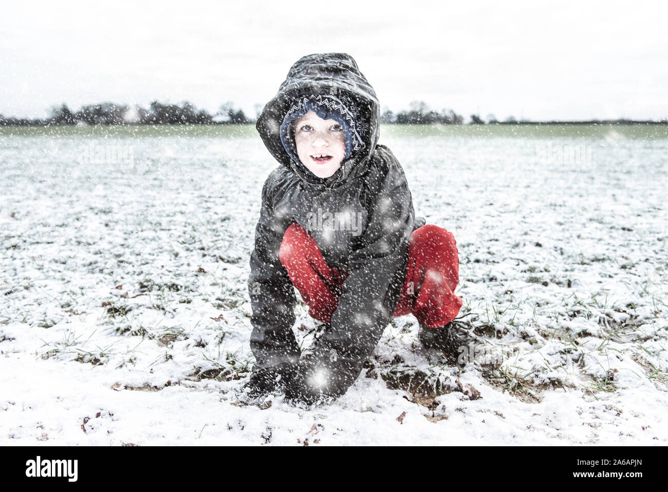 Einen kleinen Jungen mit ADHS, Autismus, Asperger-syndrom spielen in den schweren Schnee fallen, Schneebälle, zu Weihnachten, Weihnachten, Weihnachten schneit Stockfoto