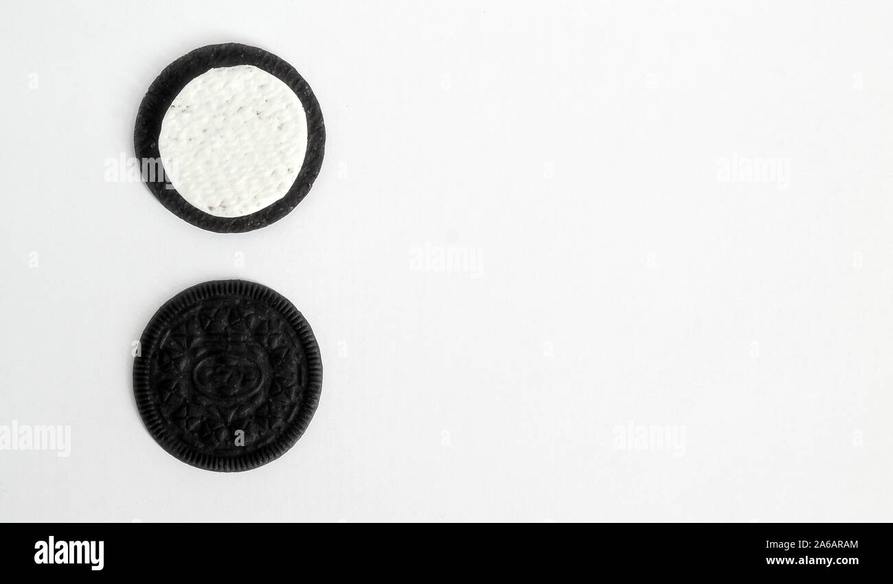 Zwei schwarze Cookies in zwei Reihen mit einem weißen Creme Center auf einem weißen Hintergrund befindet. isolieren. Stockfoto