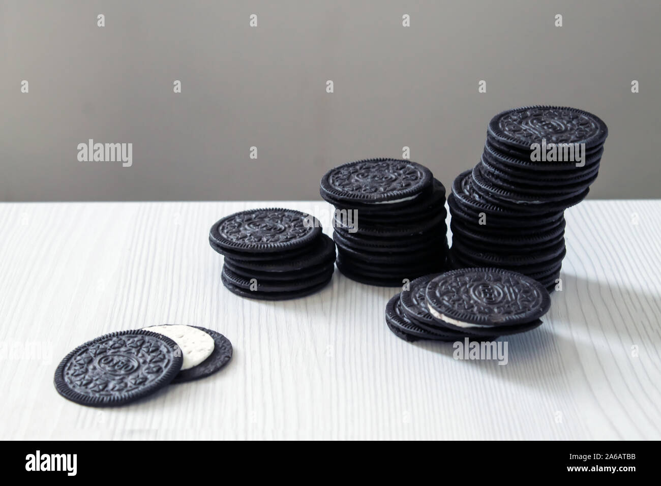 Schwarz cookies ständigen Pinnacle mit weißer Creme Center auf einem weißen Holz- Hintergrund. Stockfoto