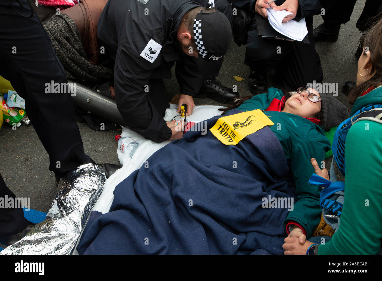 London, 10. Oktober 2019, vom Aussterben Rebellion Demonstration und Besetzung der Straßen rund um den Trafalgar Square. Zwei Frauen miteinander verknüpft, Hände halten in einem Rohr Verhaftung erwarten. Stockfoto