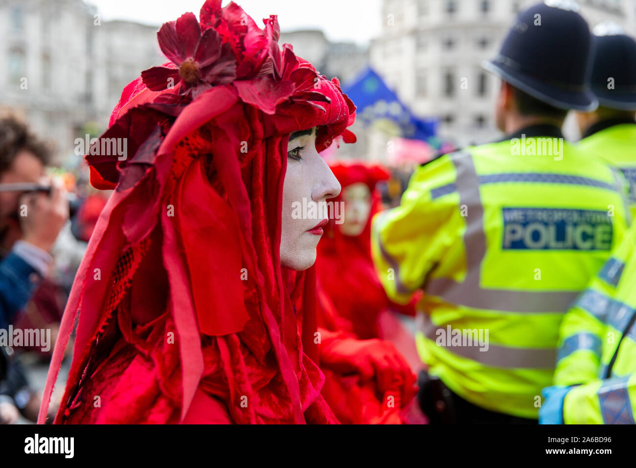 London, 10. Oktober 2019, vom Aussterben Rebellion Gruppe in rot Kostüme surround Polizei acivists vorbereiten, die sich um eine Holz- struktur in der Straße neben dem Trafalgar Square gesperrt haben zu verhaften. Stockfoto