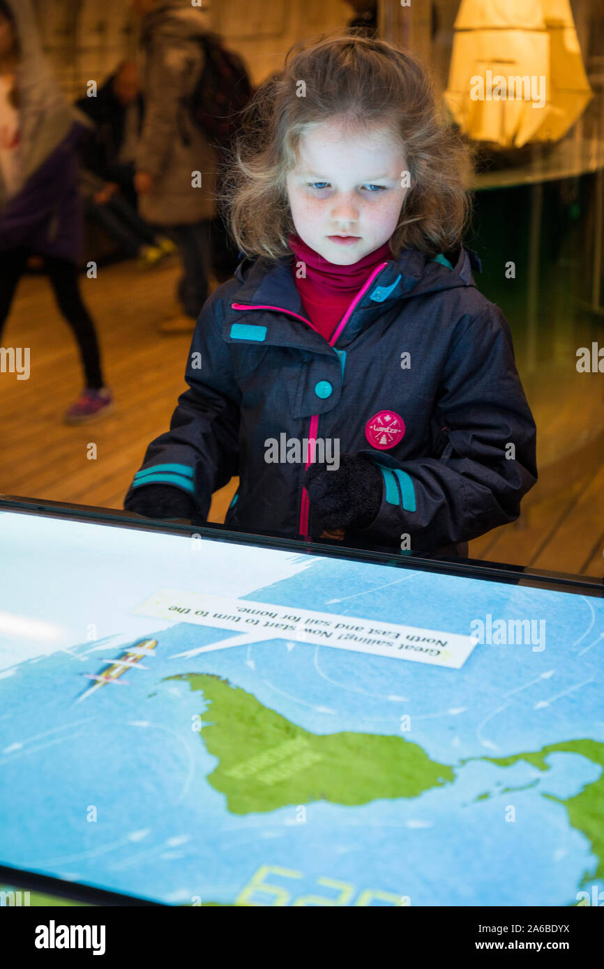 Familie und Kinder pore über interaktive Kapitän Woodget der Lenkung Spiel, eine Karte Karte der Welt weltweit die beste Route zu navigieren und, und steuern Sie den Weg/die schnellste Passage auf dem Seeweg nach Australien für Sie aus dem Vereinigten Königreich für die Segelschiff Cutty Sark. Greenwich, London UK (105) Stockfoto