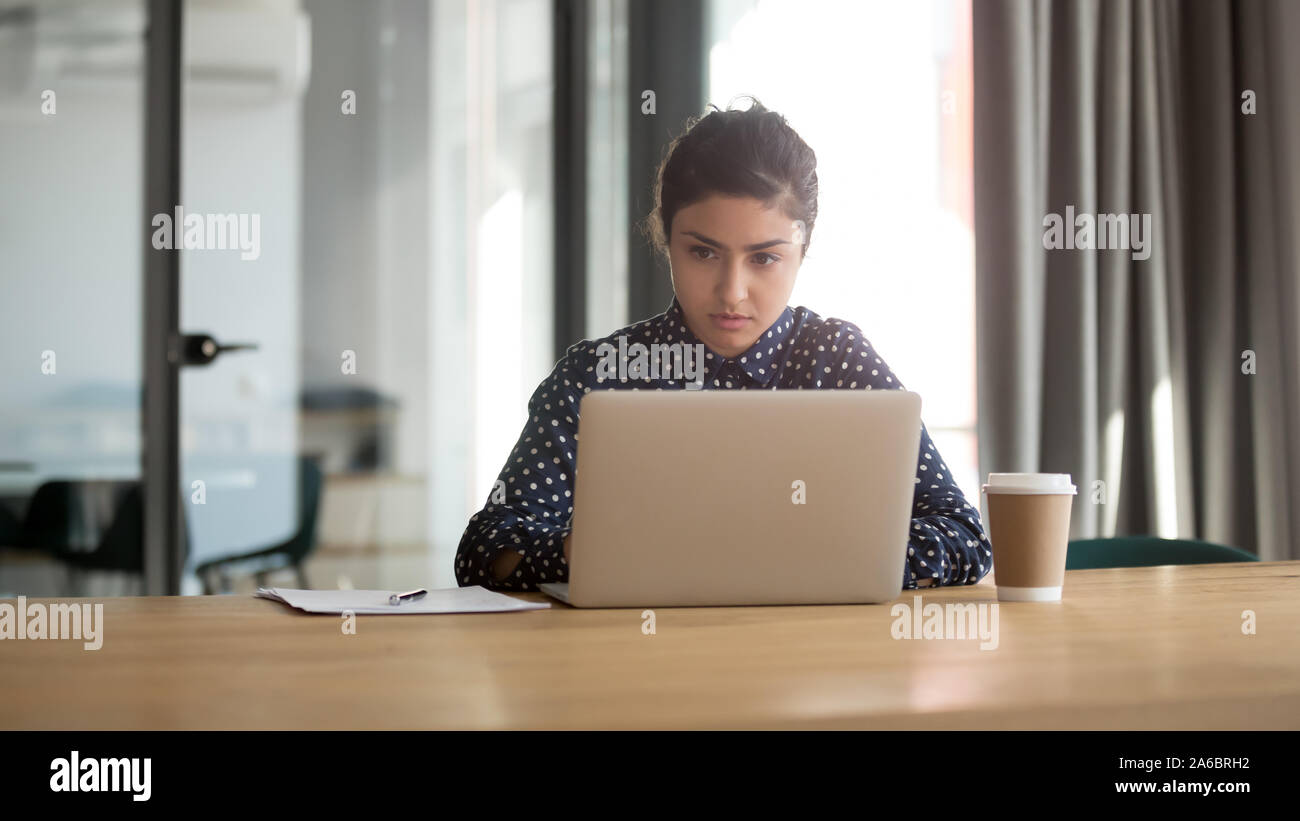 Ernsthafte indischer Mitarbeiter arbeiten am Computer im Büro Stockfoto