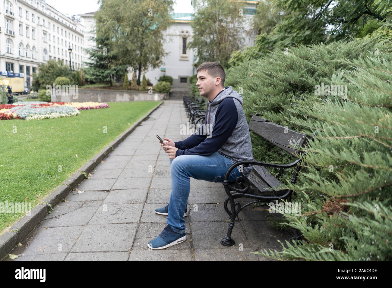 Junger Mann mit seinem Handy auf der Straße Stockfoto