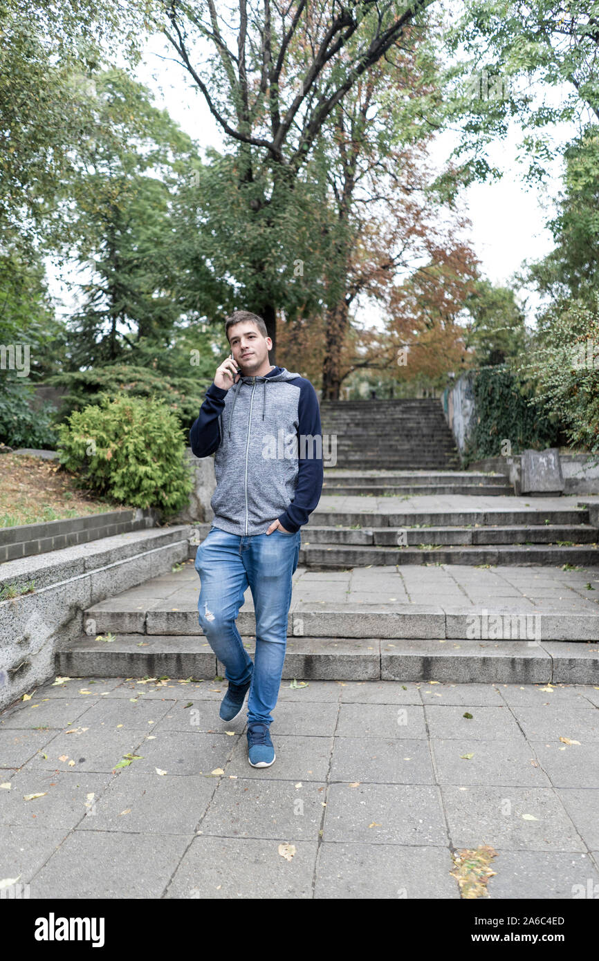 Junger Mann mit seinem Handy auf der Straße Stockfoto