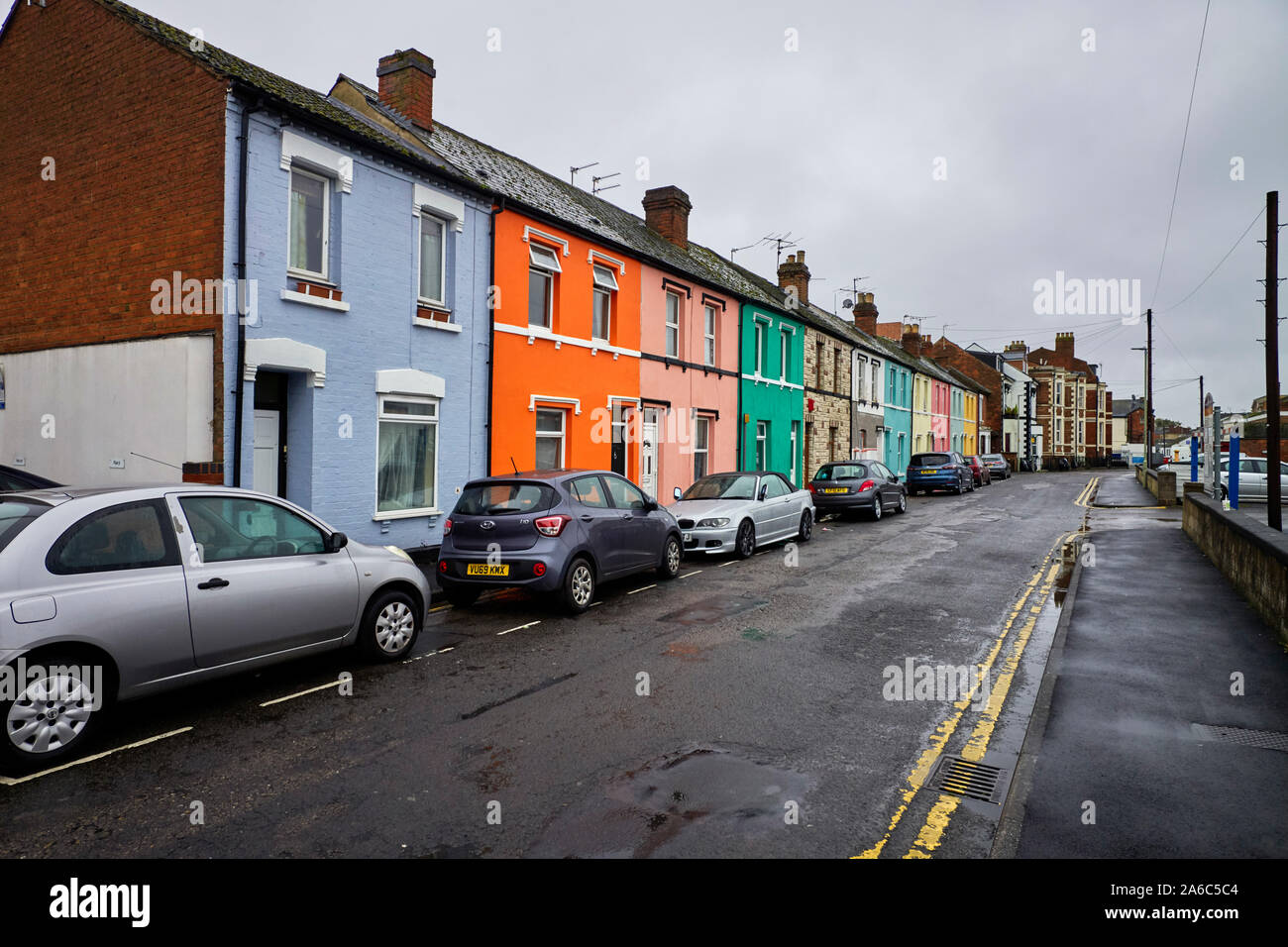 Reihe der hell gestrichenen Reihenhäuser in Nettleton Straße, Gloucester Alle lackierten Farben Stockfoto