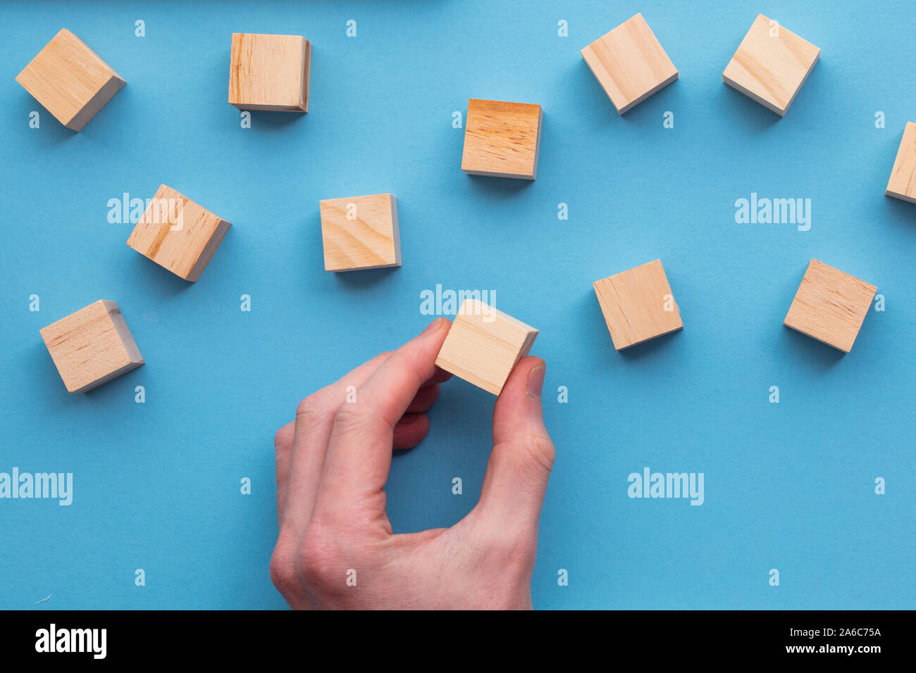 Hand wählen Sie einen Holzblock aus einem Satz. Geschäft Wahl Konzept Stockfoto