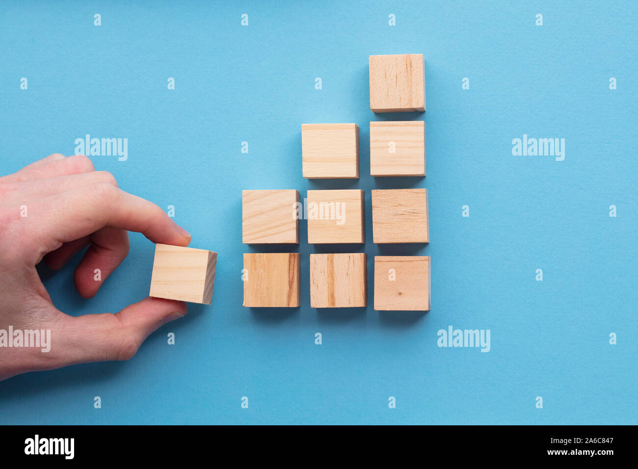 Hand wählen Sie einen Holzblock aus einem Satz. Geschäft Wahl Konzept Stockfoto