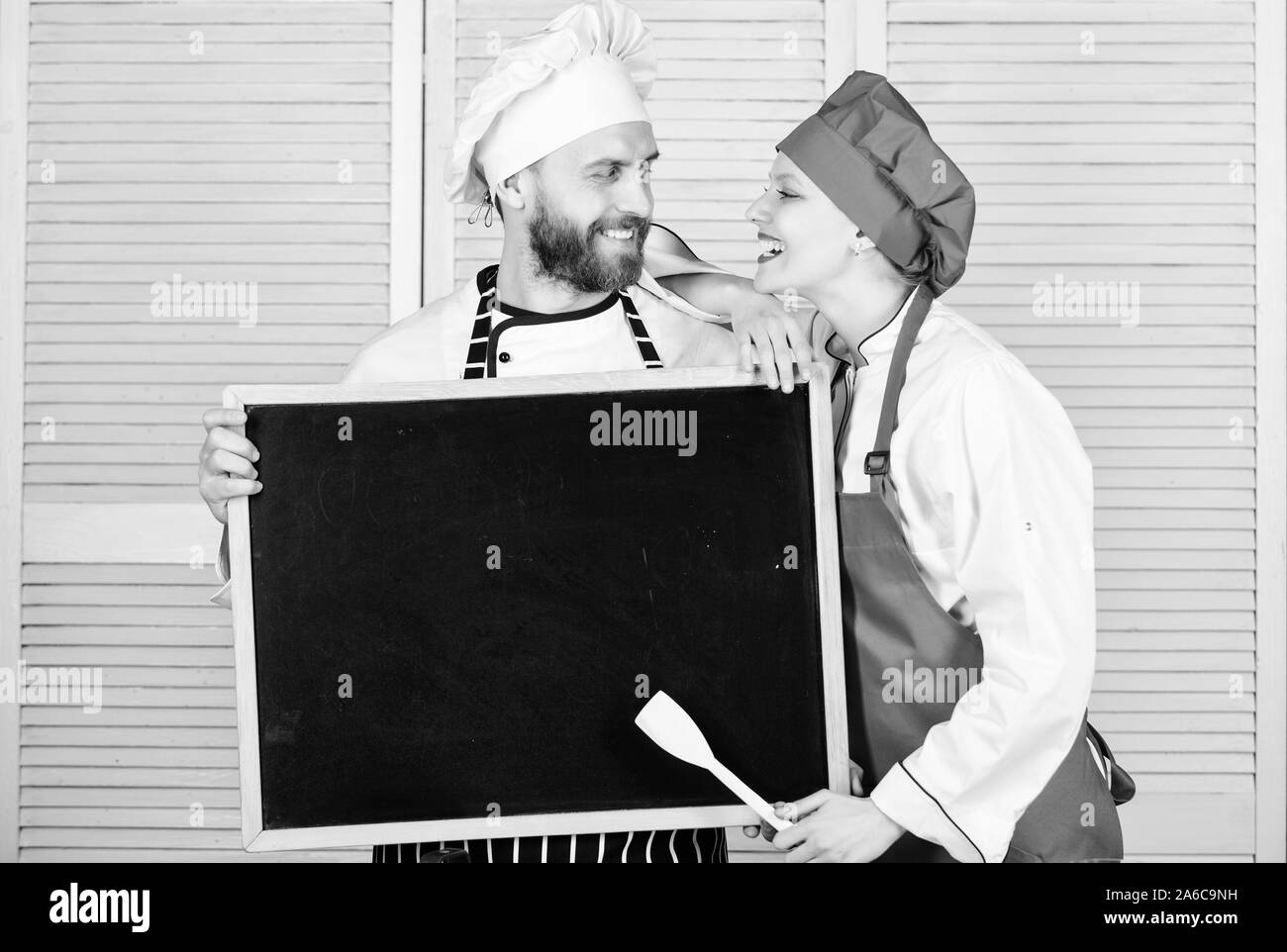 Private Kochschule. Master cook und prep Kochen, Kochkurs. Koch und Köchin Helfer Lehre master class. Paare von Mann und Frau mit leeren Tafel in Kochschule, kopieren. Stockfoto