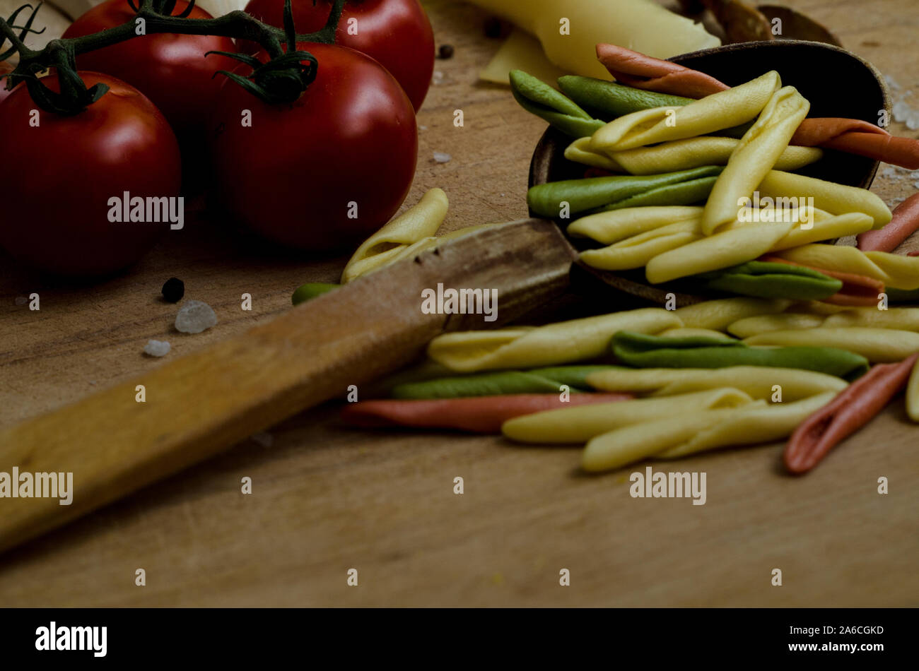 Woden Tisch voller Gemüse und farbige Pasta. Stockfoto