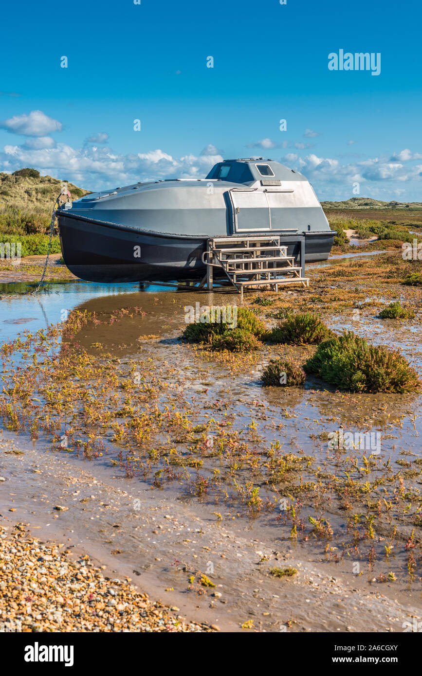 Die Graugans Lade ist ein Hausboot auf den Salzwiesen in der Nähe von Burnham Overy Staithe in der Nähe von holkham Bay an der nördlichen Küste von Norfolk, East Anglia, England, UK. Stockfoto