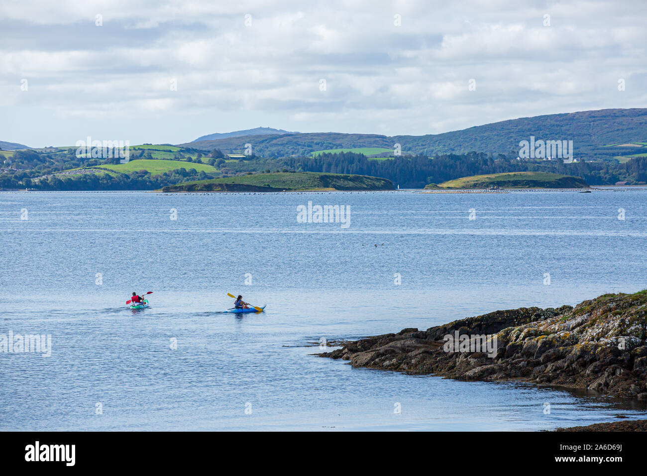 Ein Paar Kajakfahrer paddeln um die Küste der Bantry Bay in West Cork, Irland. Stockfoto