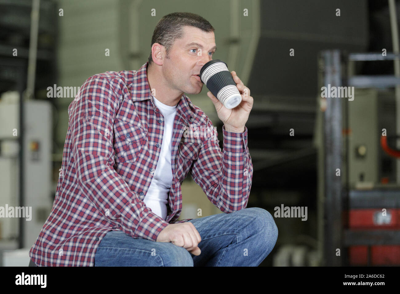 Arbeiter sitzen auf Laden Warenkorb beim Trinken von Kaffee Stockfoto