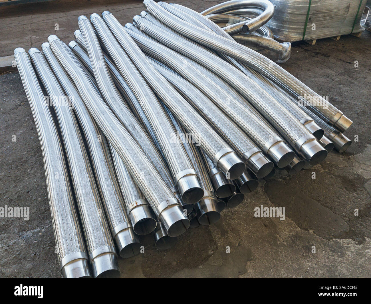 Lange Metall flexiblen Kompensator Rohre auf concerte Stock. Weißes Metall  Industriebau Stockfotografie - Alamy