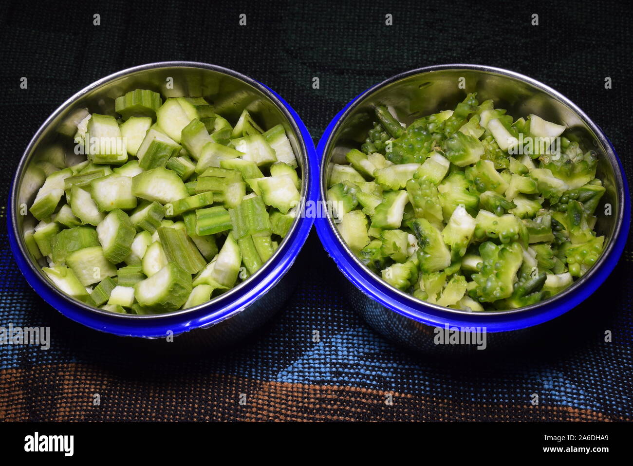 Frischen bitteren Kürbis und Okra Früchte Stücke in zwei Schalen, Stockfoto