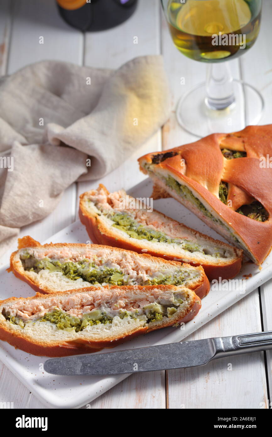 In Scheiben geschnittenen Lachs und Broccoli Torte und einem Glas Weißwein Stockfoto