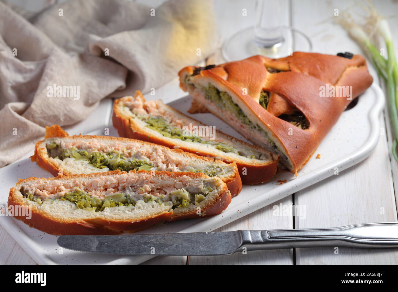 In Scheiben geschnittenen Lachs und Broccoli Torte auf einem rustikalen Tisch Stockfoto