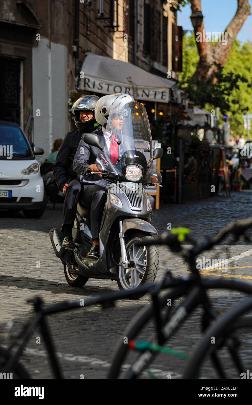 Zwei Männer in Business-Anzügen fahren ein Roller Motorrad in Trastevere  Bezirk von Rom, Italien Stockfotografie - Alamy