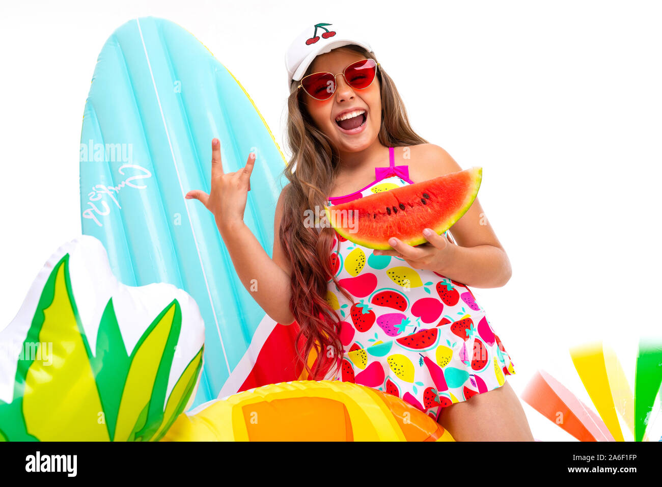 Coole Mädchen mit langen gekreuzigt Haar in Sonnenbrille und Sonnencreme, steht in der Nähe von aufblasbaren Matratzen mit einer Wassermelone Stockfoto