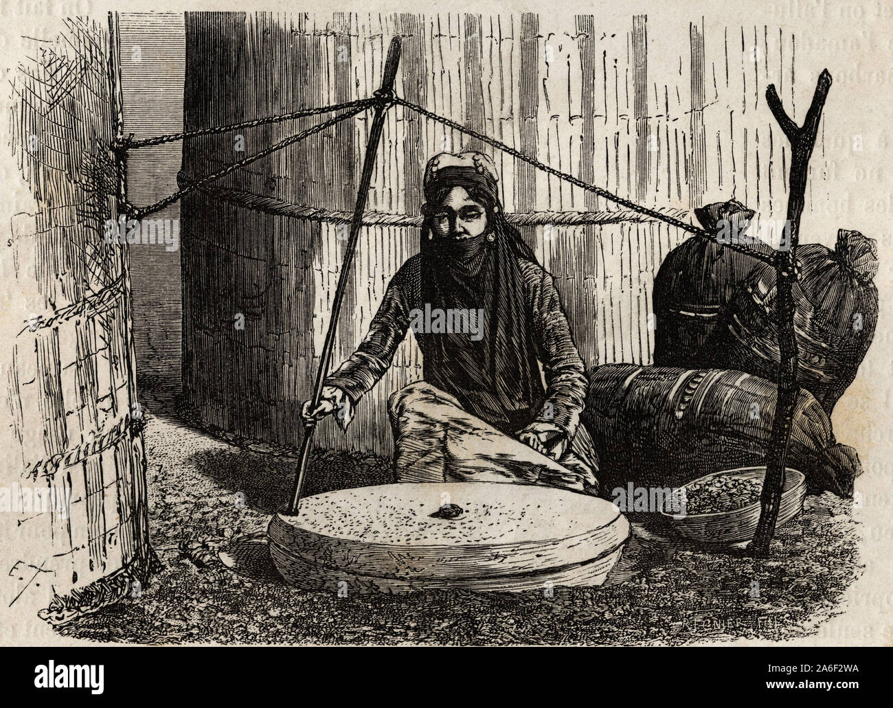 Femme turcomane utilizant La meule ein Korn, en ingenieux actionnant Un systeme de manivelle, la Pierre superieure Tourne et le frottement de cette pie Stockfoto