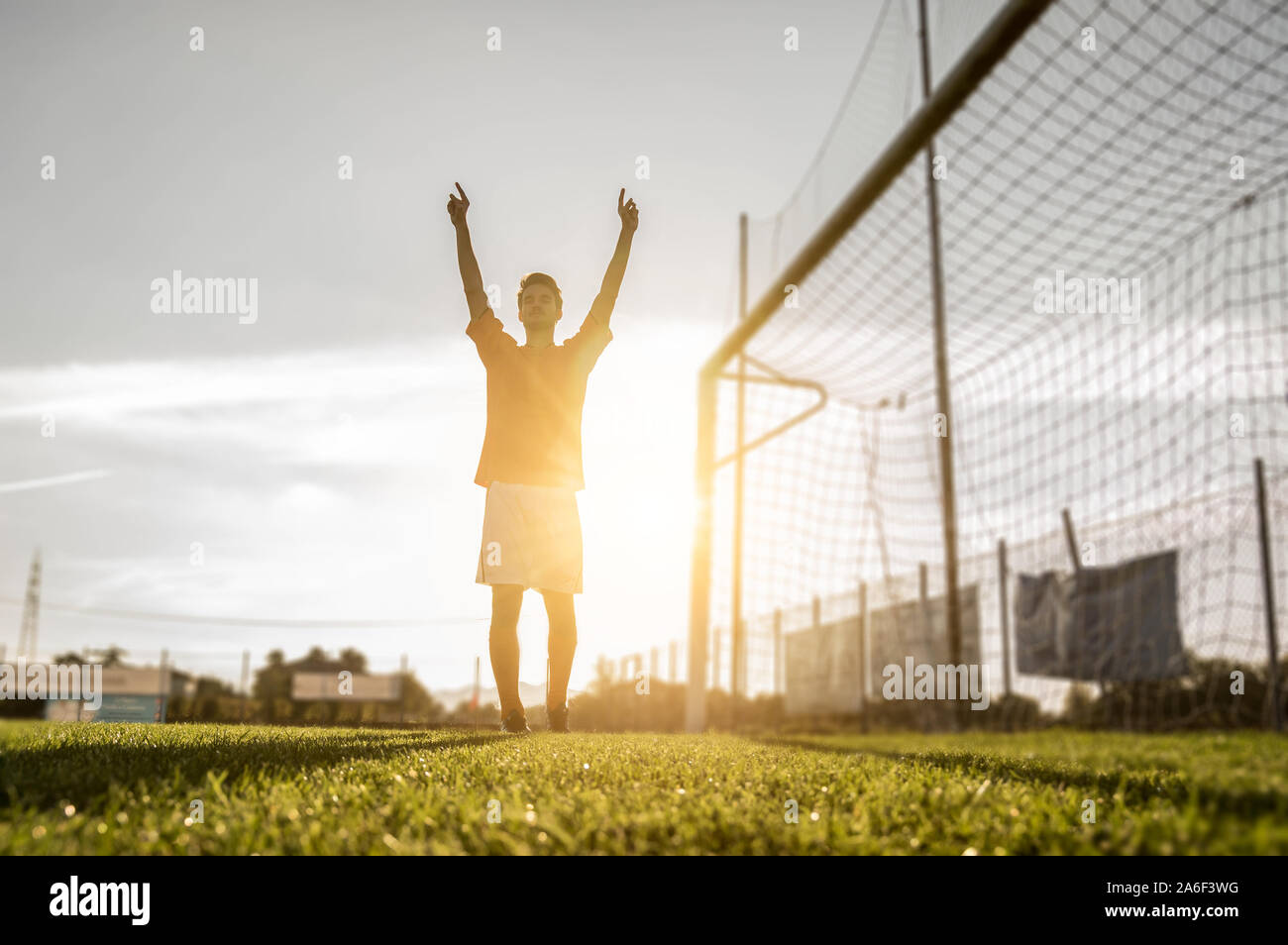 Erfolgreiche Fußball-Spieler lachte, bis seine Arme in den Himmel. Konzept für Sport Stockfoto