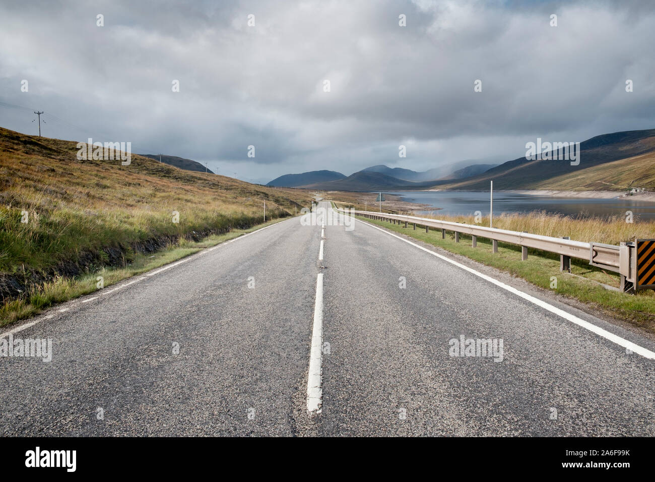 Long straight stretch of empty road leading to mountains in Sutherland in the Scottish Highlands Stockfoto