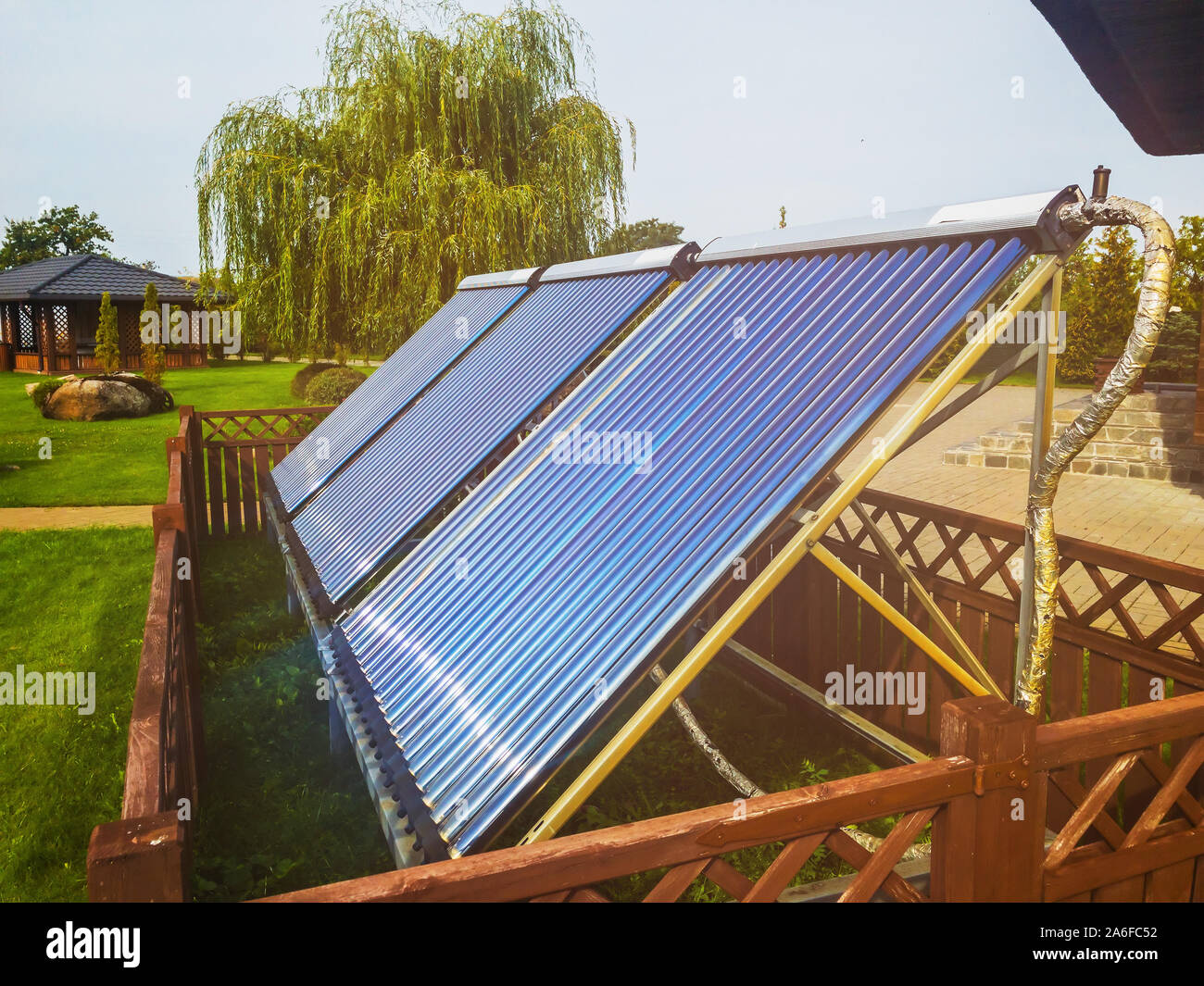Vakuumkollektoren auf dem Hinterhof. Eco Energiekonzept. Sonnenkollektoren für die Warmwasserbereitung mit Lens Flare. Für alle purprose verwenden. Stockfoto