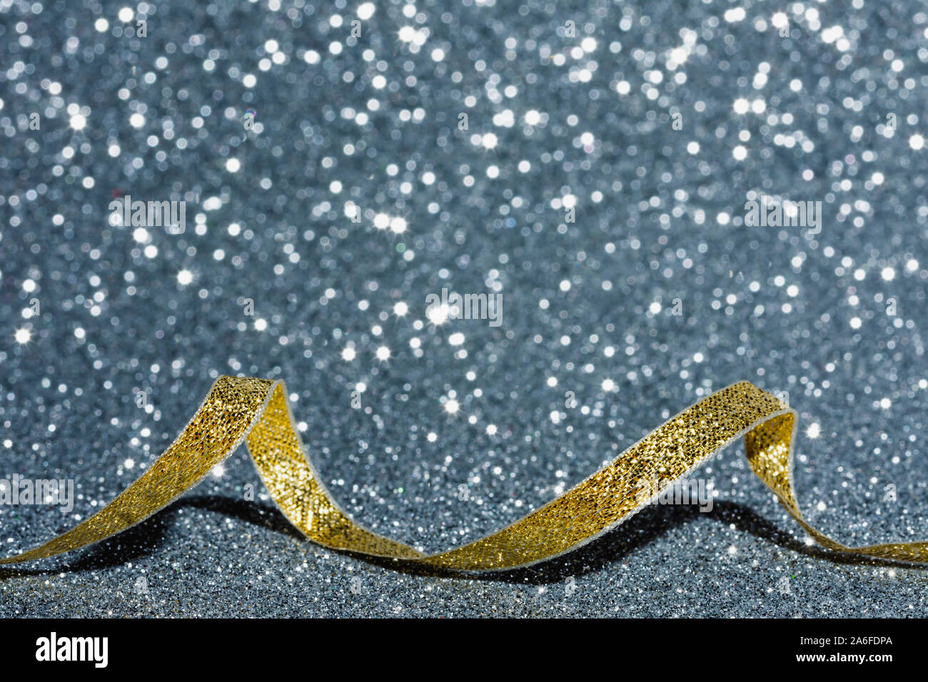 Golden christmas Ribbon auf silbernem Hintergrund, kopieren Raum Bild, Weihnachtskarte mit Defokussierten Glitzereffekt Stockfoto