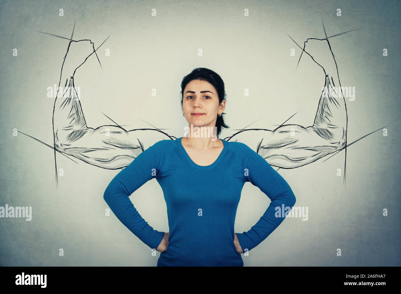 Mutige Frau, die Hände auf den Hüften, mit Blick auf die Ängste wie eine mächtige Helden wie muskulösen Arme Skizzen auf der Wand Ihrer inneren Stärke zeigen. Starkes Mädchen bi angezeigt Stockfoto