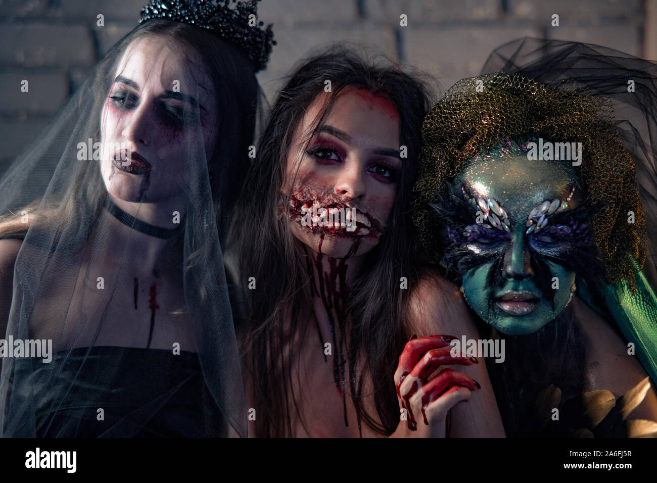 Drei Frauen in einem Karneval Kostüme von einem Vampir Braut in schwarz Hochzeit Kleid, schwarz Schleier und Diadem. Halloween Konzept. Stockfoto