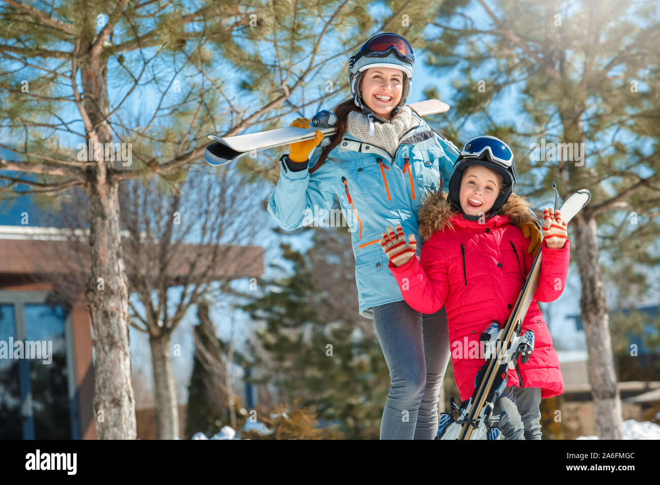 Winter Urlaub. Zeit mit der Familie zusammen im Freien Frau und Mädchen in eine Schutzbrille mit Skiern Posing, Thum, lächelt Fröhlich Stockfoto