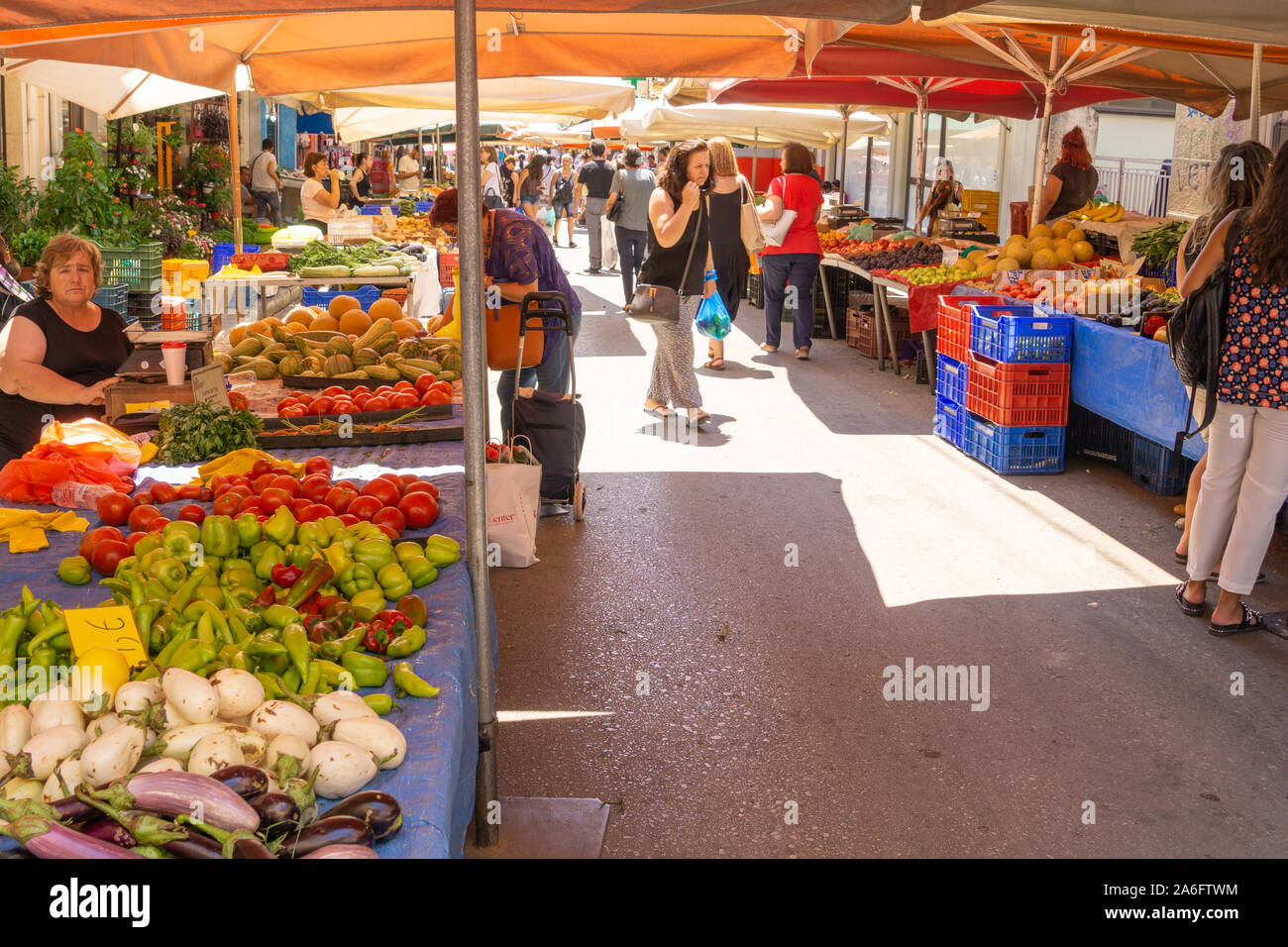 Lamia Griechenland - 26. Juli 2019; die Leute mit ihren Einkäufen Spaziergang zwischen Stadt Street Market verdors Stände produzieren ihre Einkäufe tragen Stockfoto