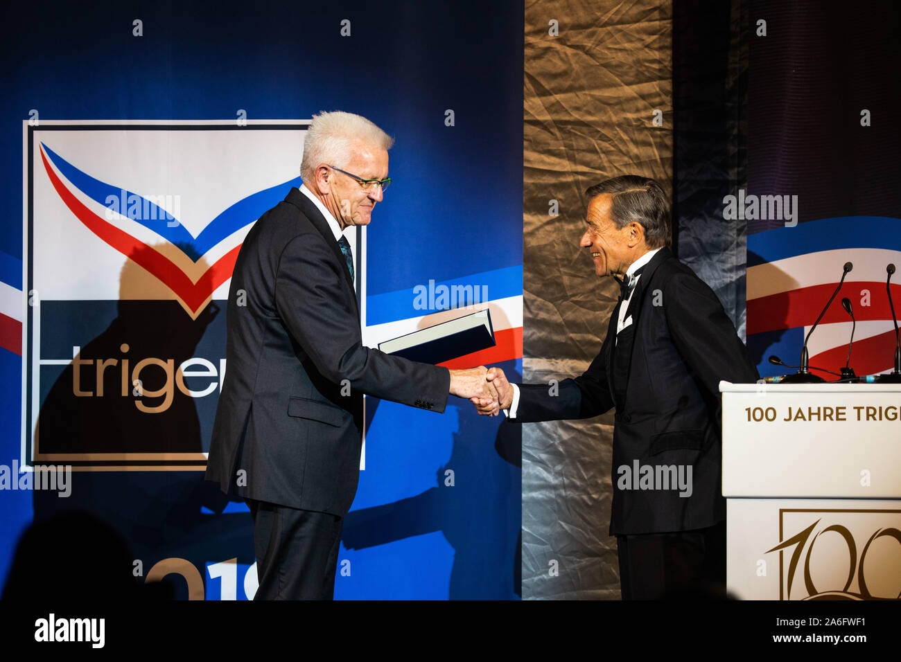 Burladingen, Deutschland. 26 Okt, 2019. Winfried Kretschmann (l, Bündnis 90/Die Grünen), Ministerpräsident des Landes Baden-Württemberg, ausgezeichnet mit dem Bundesverdienstkreuz erster Klasse, Wolfgang Grupp, Unternehmer, bei der Feier von 100 Jahren von Trigema. Die Firma hatte von Grupp's Großvater und seinem Bruder gegründet worden. Zusätzlich zu den fast 1500 Trigema Arbeitnehmer und Rentner, eine illustre Runde von Gästen aus Politik, Wirtschaft und des Adels wurde eingeladen, Jahrestag der Textilunternehmen zu feiern. Credit: Philipp von Ditfurth/dpa/Alamy leben Nachrichten Stockfoto