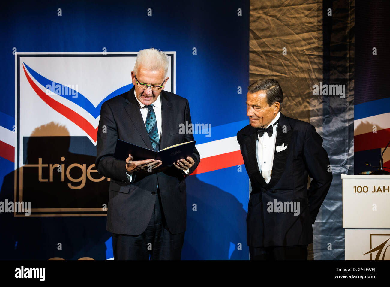 Burladingen, Deutschland. 26 Okt, 2019. Winfried Kretschmann (l, Bündnis 90/Die Grünen), Ministerpräsident des Landes Baden-Württemberg, ausgezeichnet mit dem Bundesverdienstkreuz erster Klasse, Wolfgang Grupp, Unternehmer, bei der Feier von 100 Jahren von Trigema. Die Firma hatte von Grupp's Großvater und seinem Bruder gegründet worden. Zusätzlich zu den fast 1500 Trigema Arbeitnehmer und Rentner, eine illustre Runde von Gästen aus Politik, Wirtschaft und des Adels wurde eingeladen, Jahrestag der Textilunternehmen zu feiern. Credit: Philipp von Ditfurth/dpa/Alamy leben Nachrichten Stockfoto