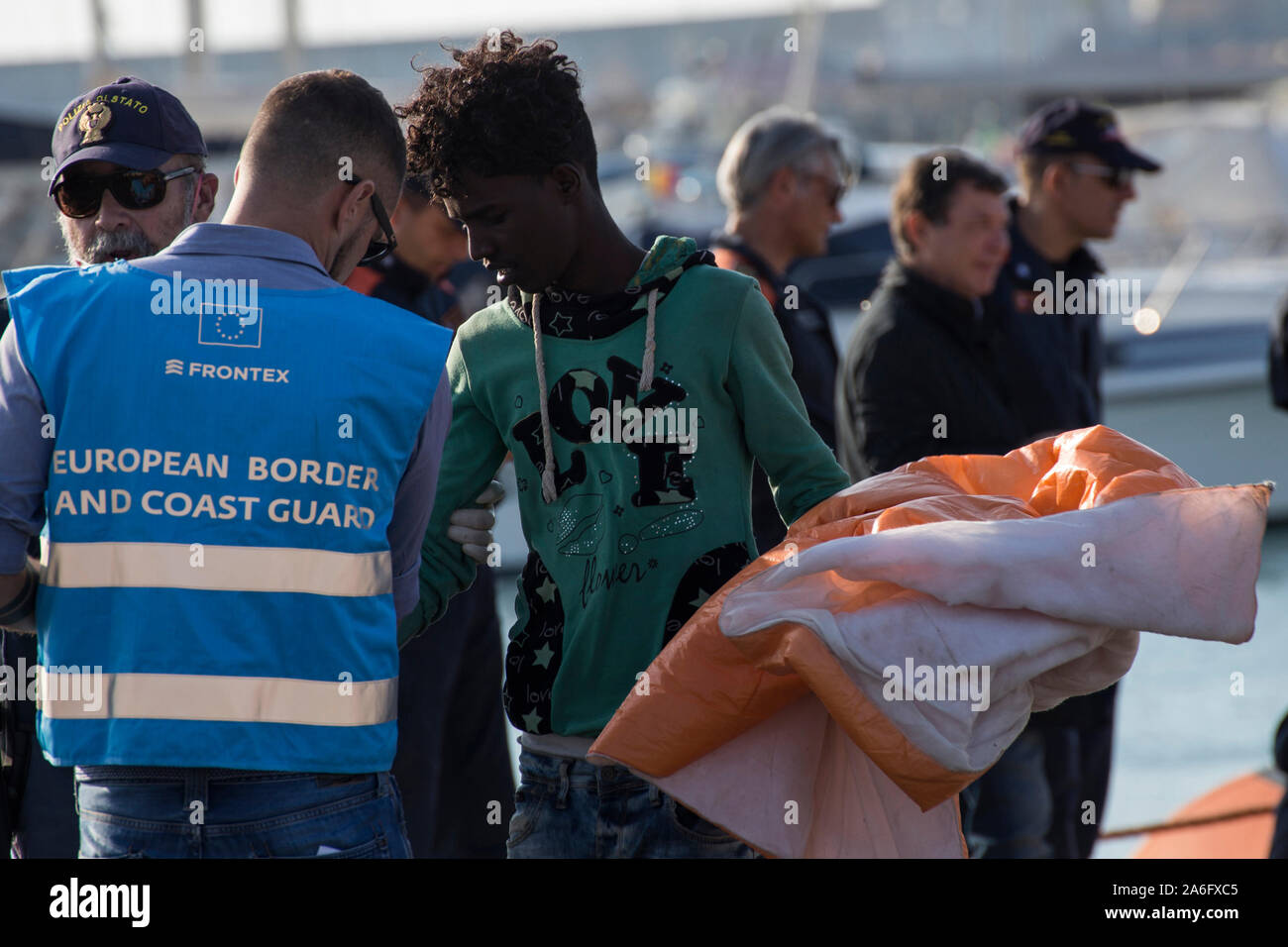 Pozzallo, Italien. 22 Okt, 2019. Ein Migrant wird von der FRONTEX-Mitarbeiter vor dem Verfahren der Identifizierung geholfen. 67 Migranten in Pozzallo Hafen umgeladen mit CP 324 von kirchenschiff Diciotti, sowohl italienische Küstenwache Schiffe aussteigen. Zuvor die Menschen, wich von Libyen und sie wurden gerettet am Mittelmeer von Handelsschiff Asso 29, den Betrieb der Italienischen Ölfirma ENI, die meisten von ihnen stammen aus Somalia und einige haben sichtbare Anzeichen von Folter erlitten am Lybischen Haftanstalten. Credit: SOPA Images Limited/Alamy leben Nachrichten Stockfoto