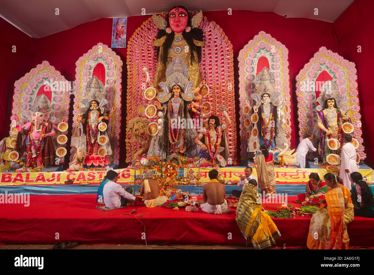 Während der Hindu Festival der Durga Puja in Mumbai, Indien, Gläubigen und Priester versammeln sich vor einer großen Statue von Durga und anderen hinduistischen Zahlen Stockfoto